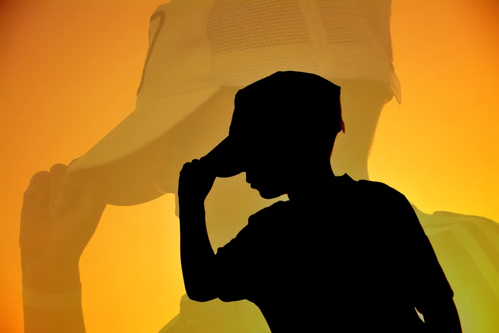 Silhouette eines jungen Mannes vor goldenem Abendhimmel