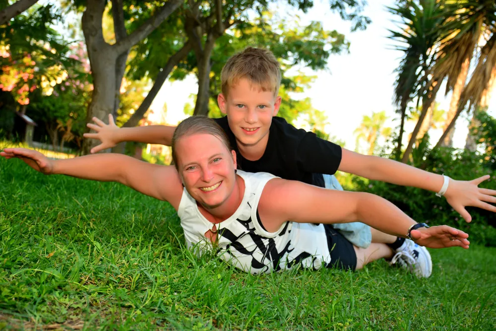 Mutter und Sohn strecken lachend die Arme aus