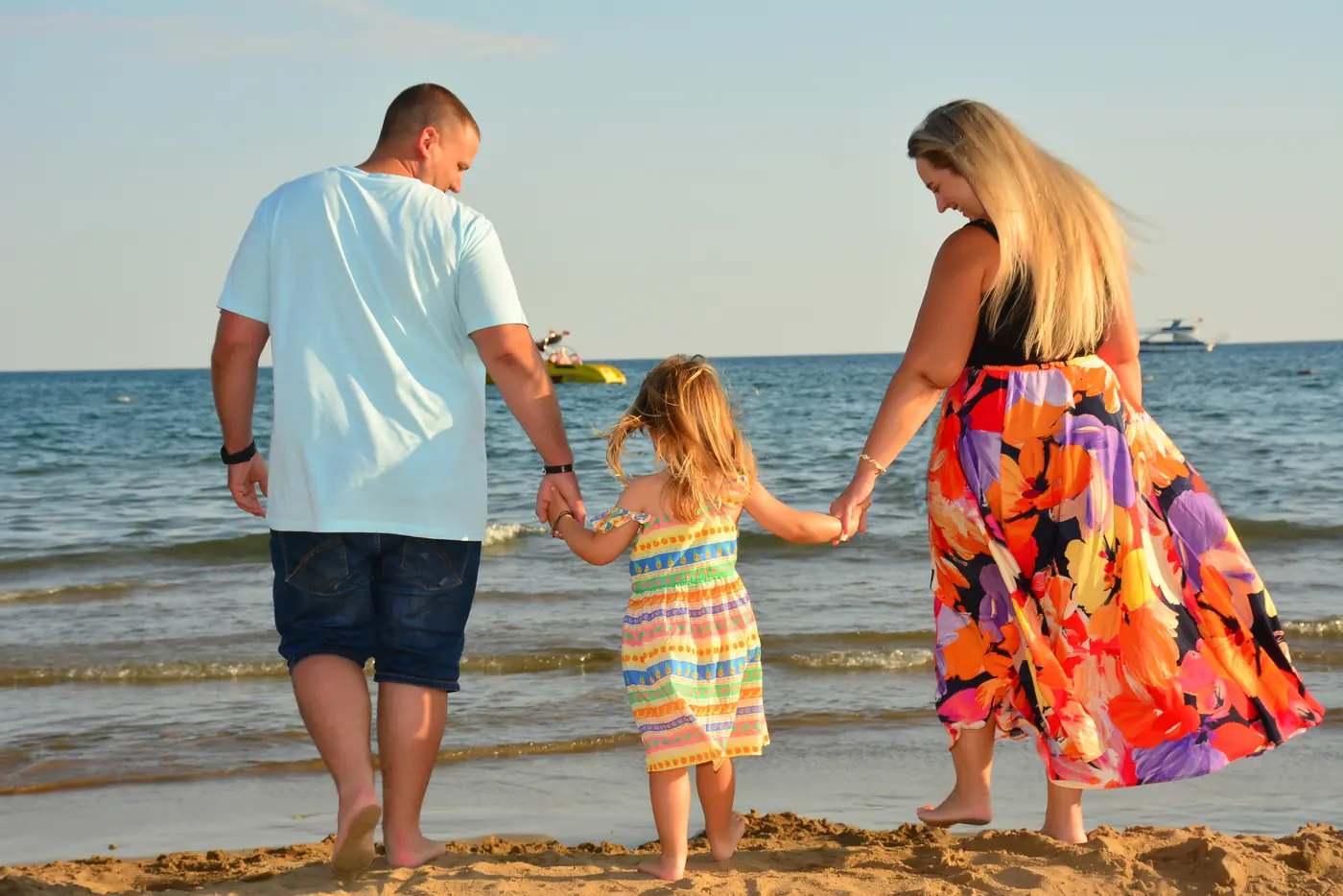 Familie Hand in Hand am Strand im Sonnenuntergang