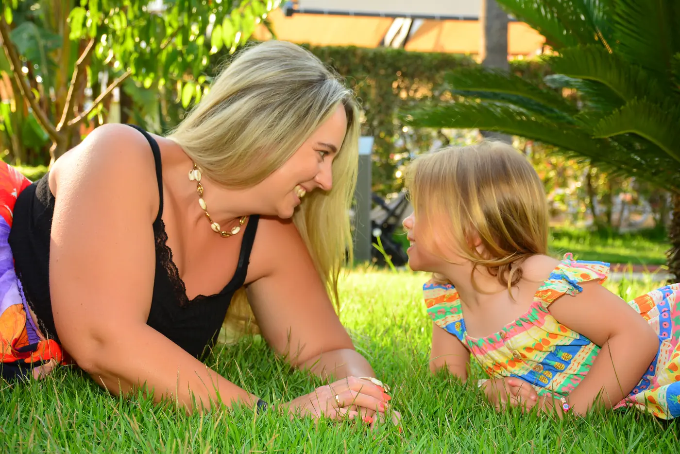 Mutter und Tochter lachen im Gras