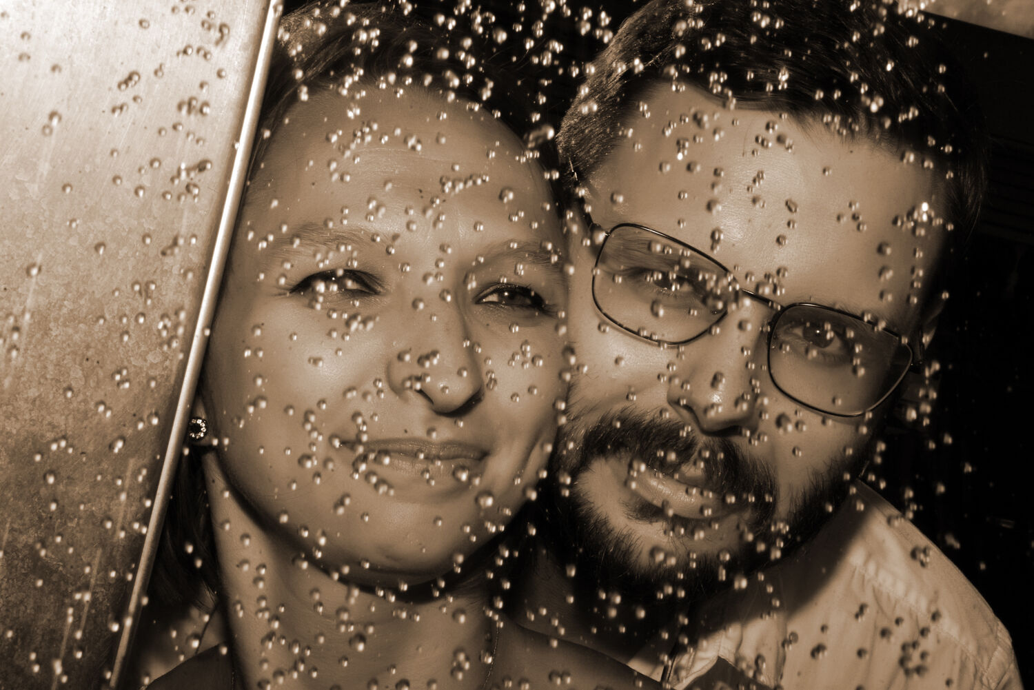 Kreatives Paarportrait hinter Wassertropfen