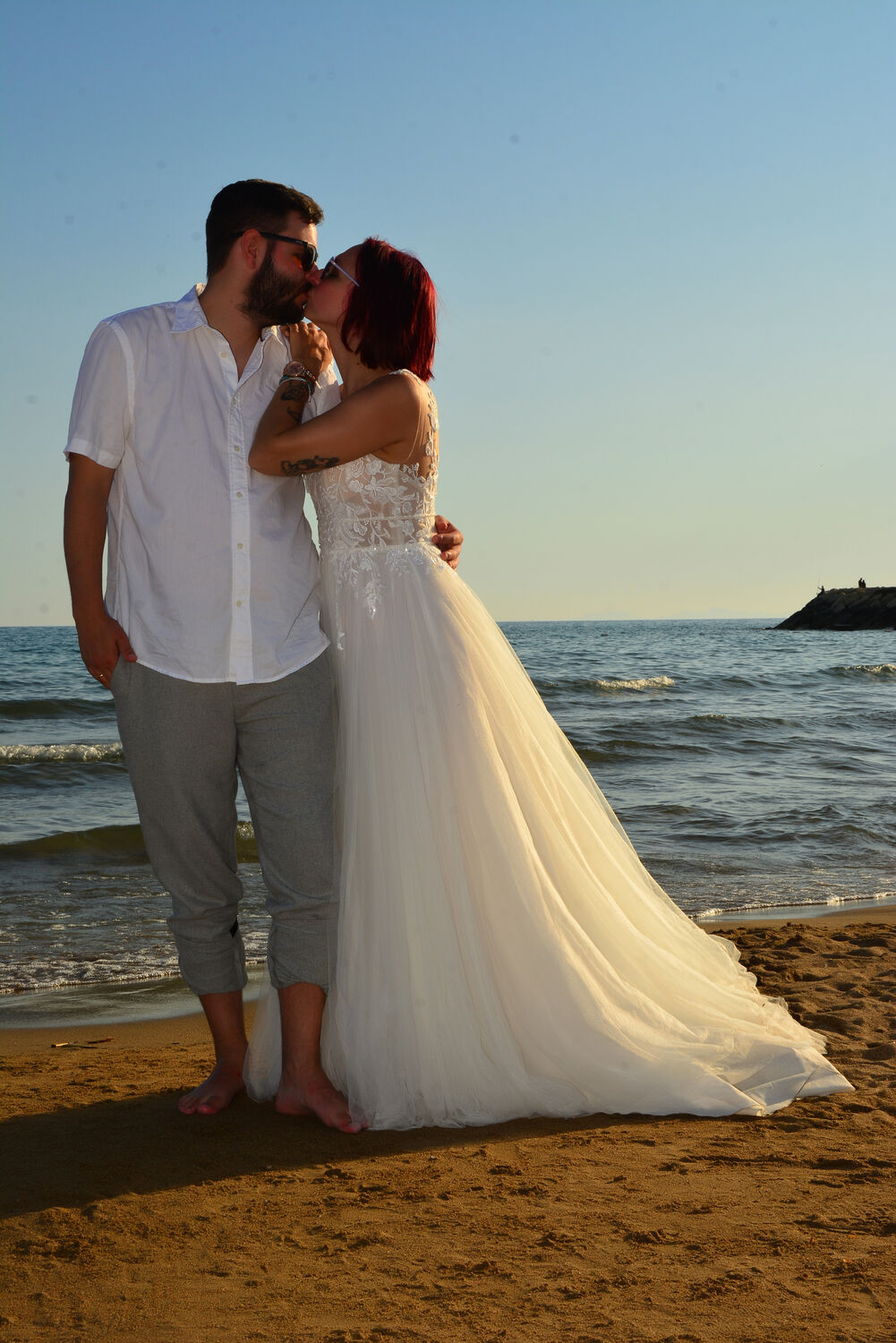 Brautpaar umarmt sich im Abendlicht am Strand