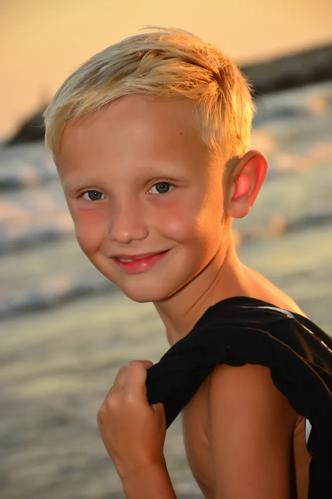 Porträt eines Jungen am Strand im Abendlicht
