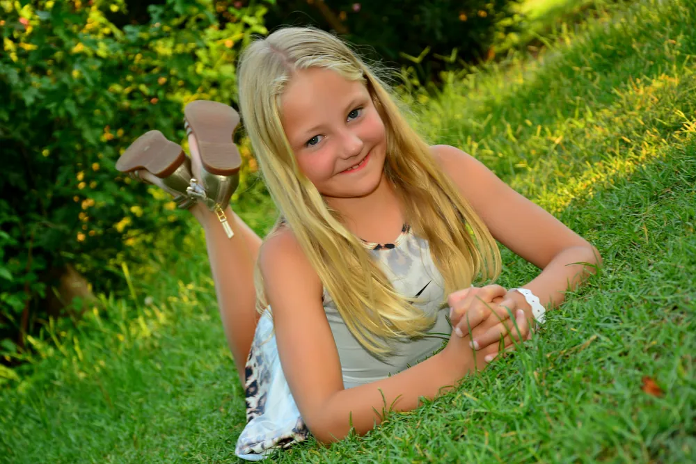 Mädchen mit langen blonden Haaren im Gras