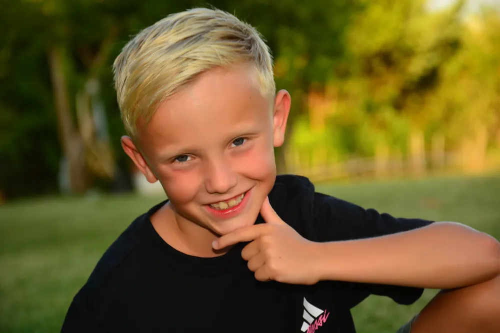 Porträt eines lachenden Jungen im Grünen