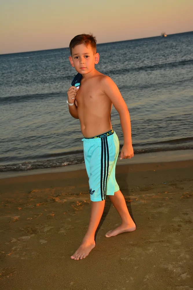 Junge läuft am Wasser entlang, Hochformat