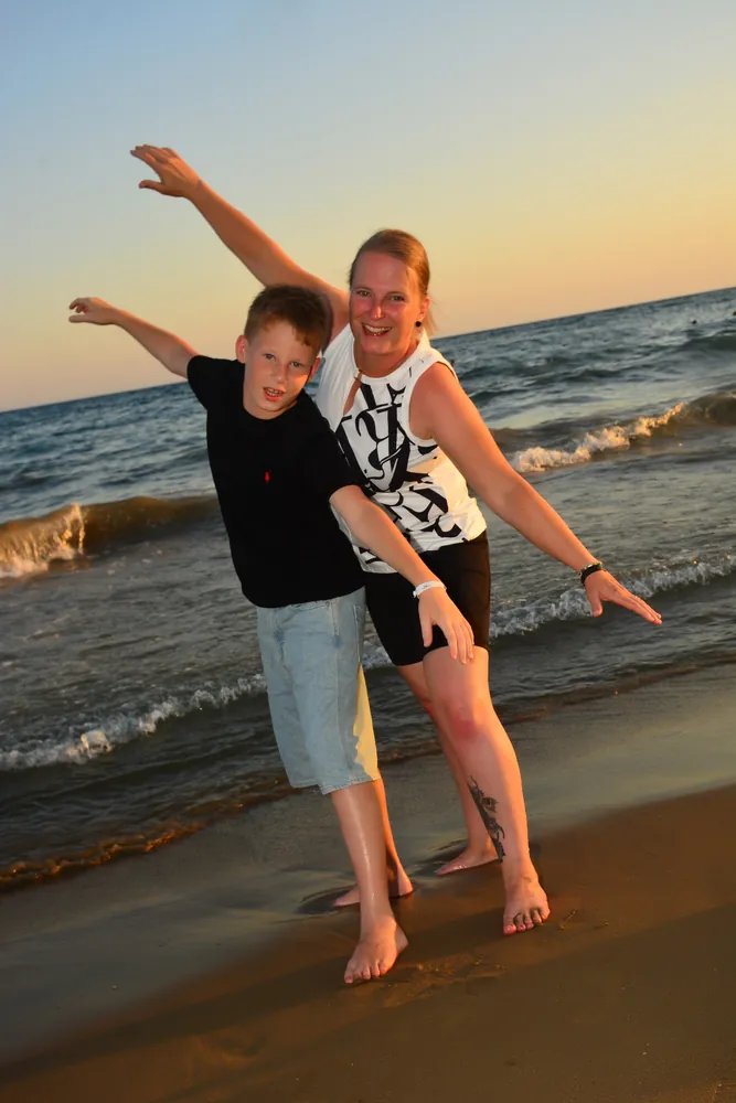 Vater und Sohn posieren ausgelassen am Strand